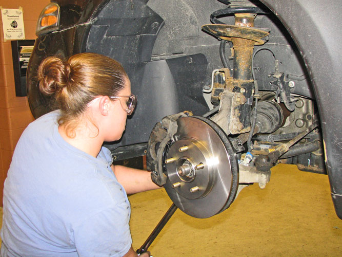 Student inspecting brake assembly