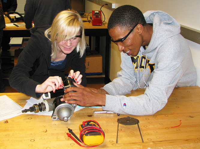 Students working on car parts on work bench