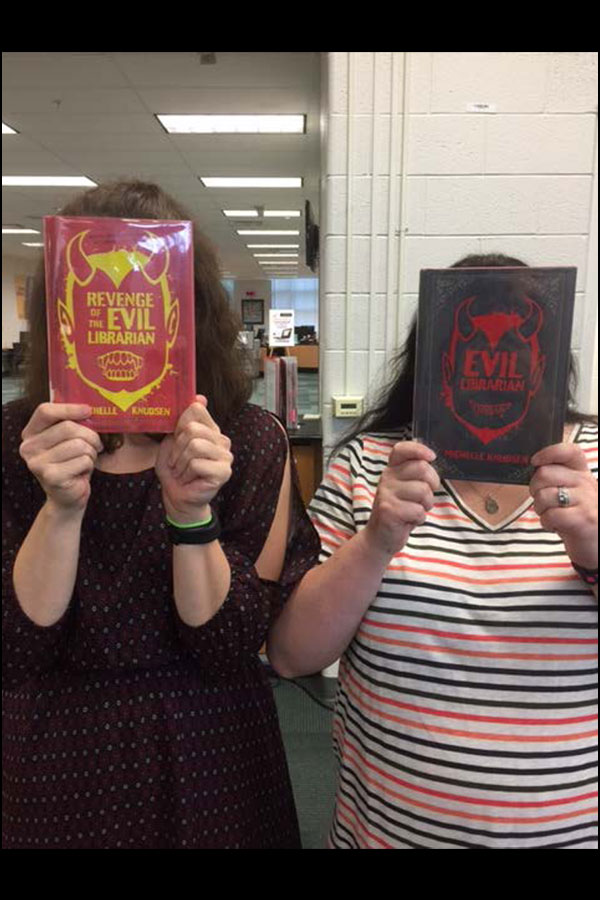 Jess and Tess covering face with faces on books