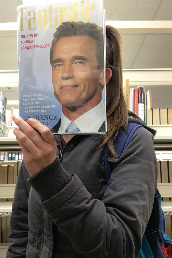 Kori covering face with face on a magazine
