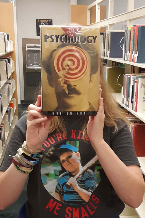 Megan covering face with face on a book