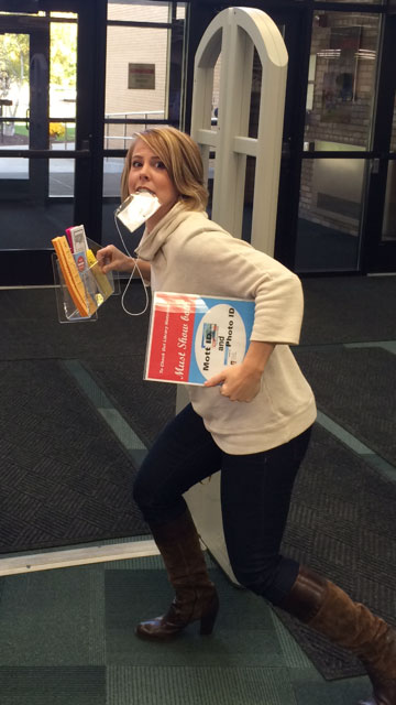 Staff member taking selfie as part of scavenger hunt at library exit
