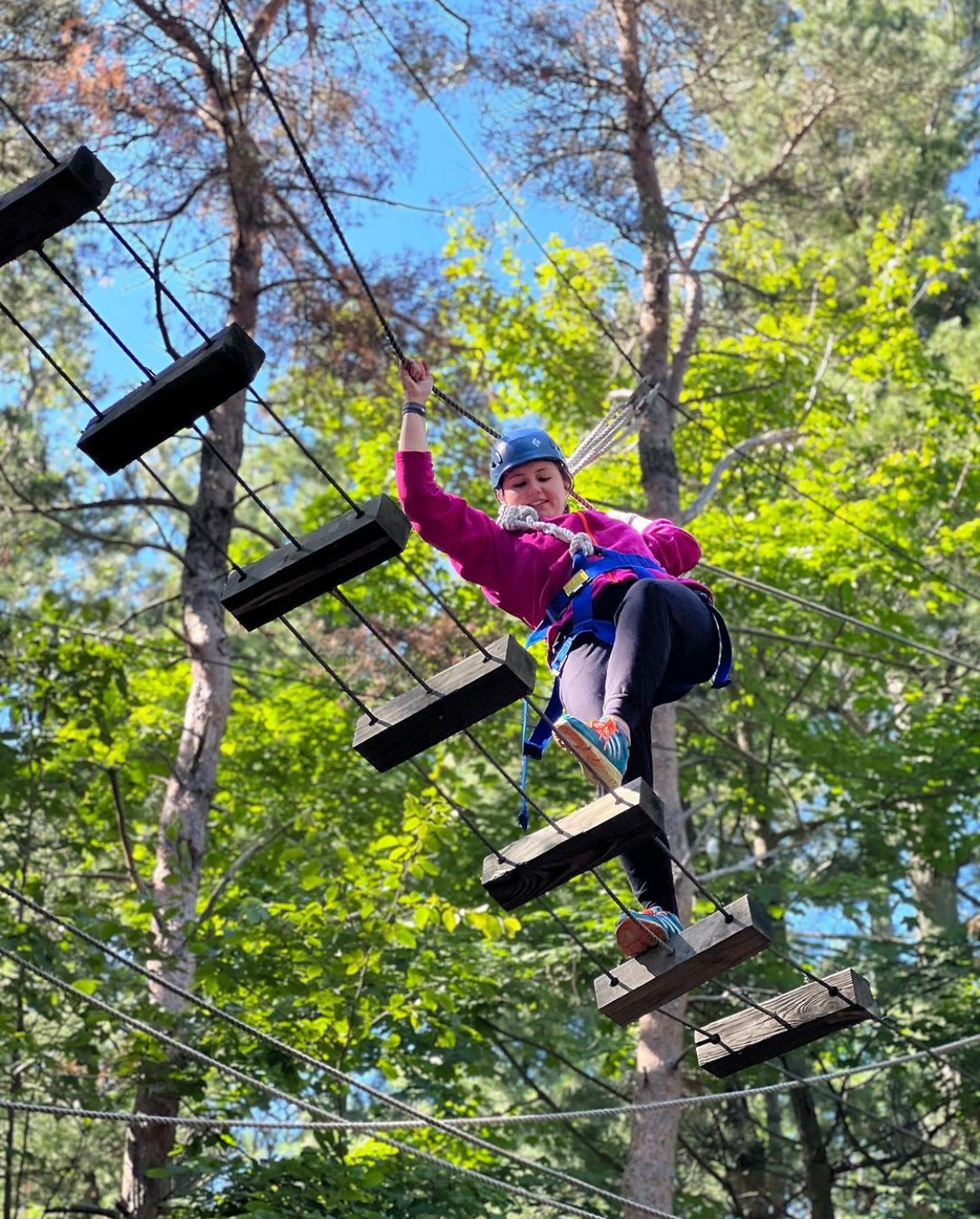 Student walking on a rope ladder bridge