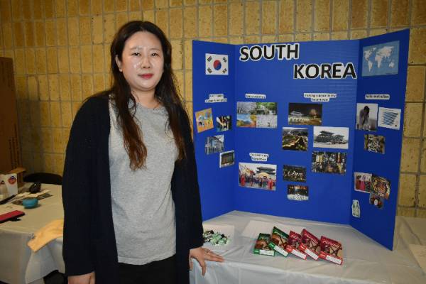 student displaying information poster at event