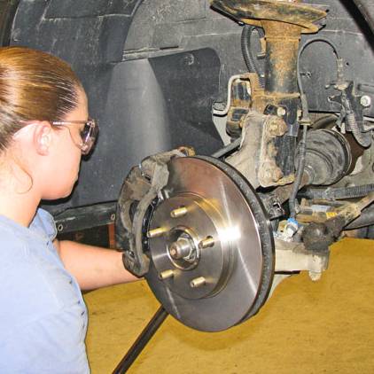 students working on a brakes on car